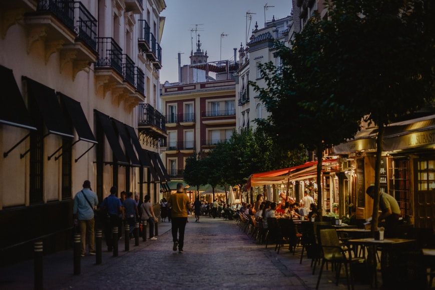Una via di Siviglia con i locali per una cena con tapas, pesce e non solo